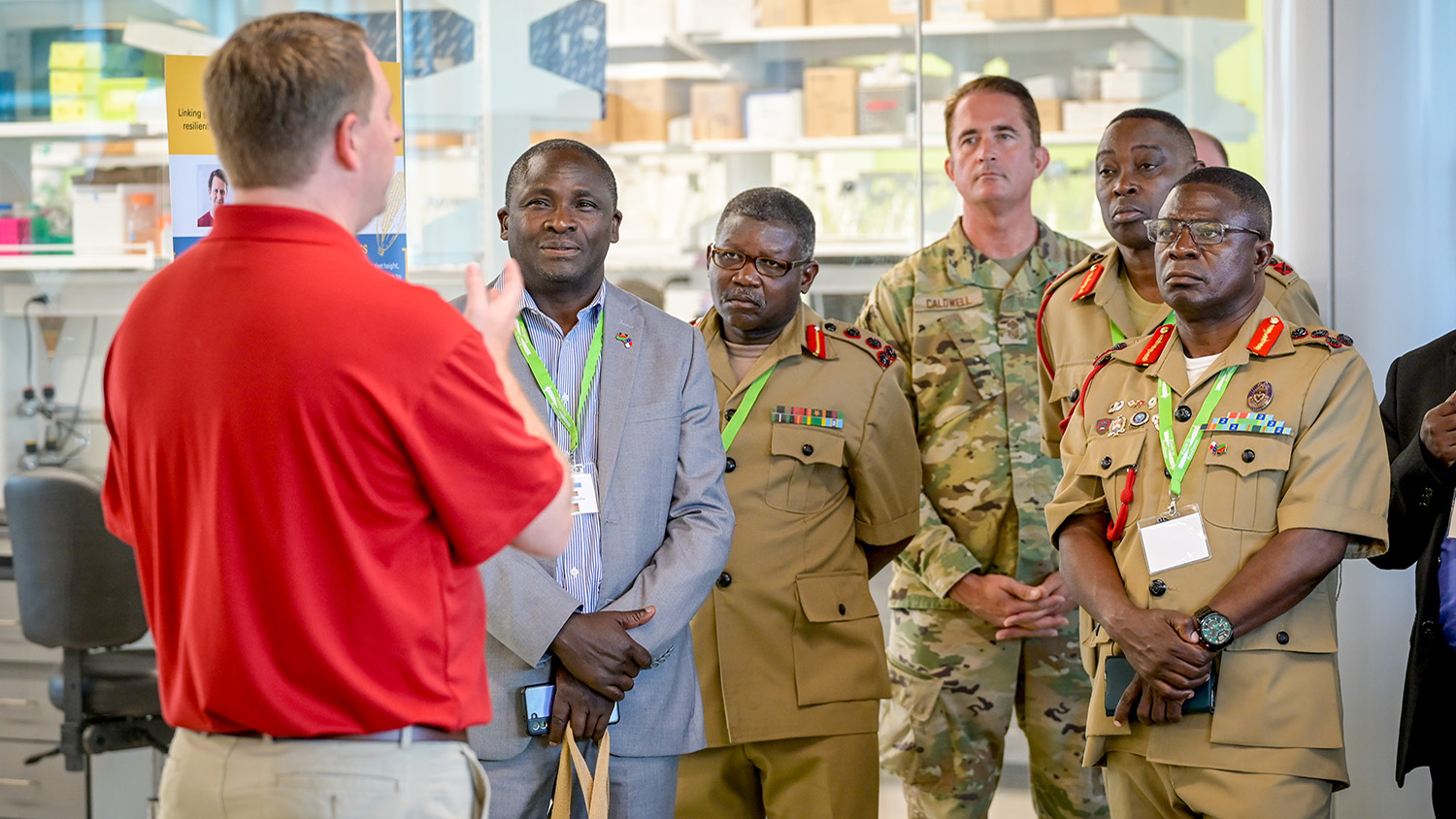 a man talks to a group in front of a agriculture lab