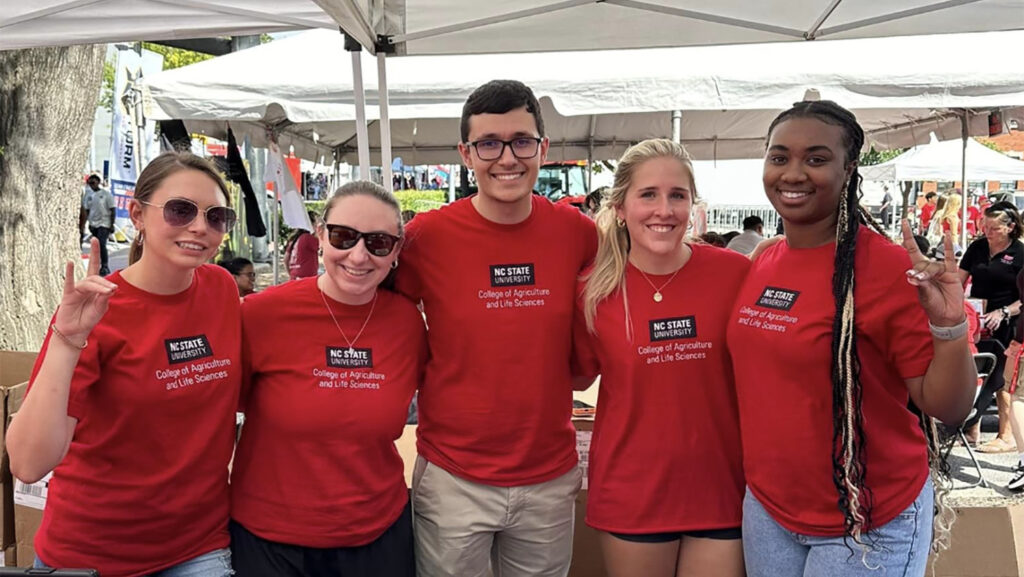 five people in red t-shirts smiling