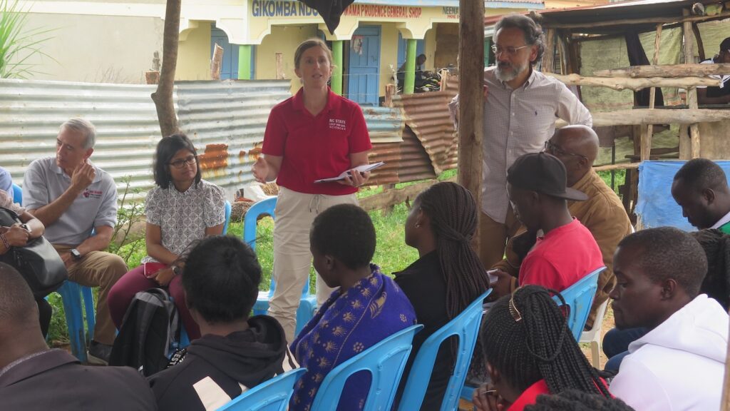 A seated group listens to a moderator.