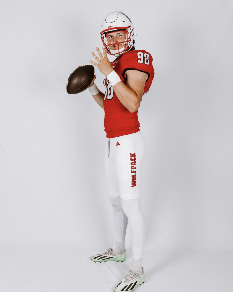 man wearing a football uniform holding a football