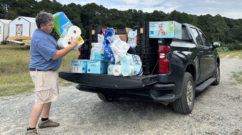 a man off loads supplies from a pickup truck