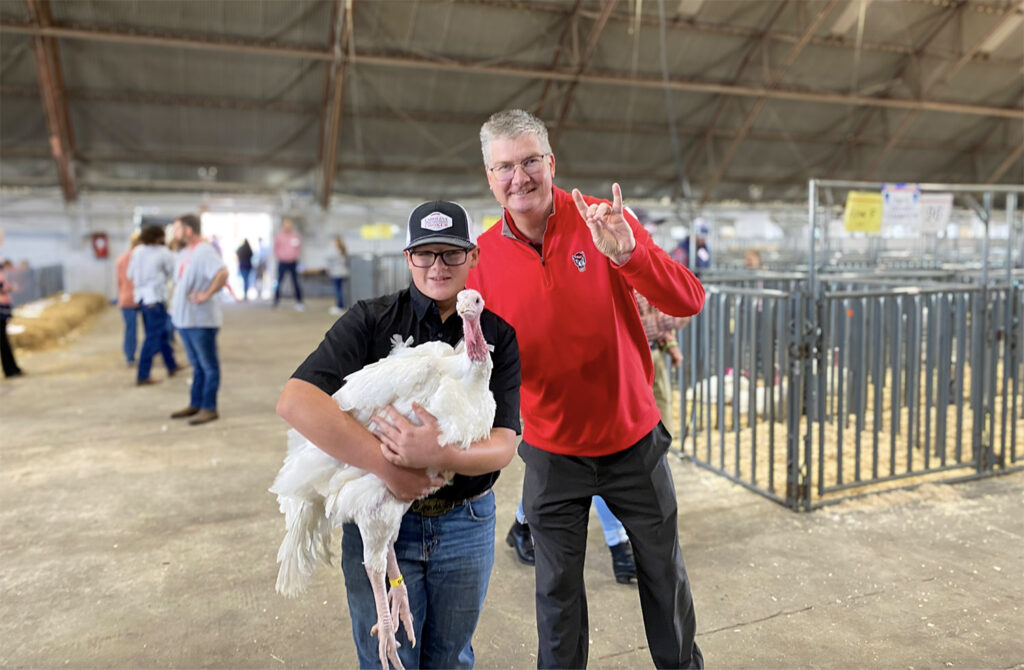 a man stand with a boy holding a turkey