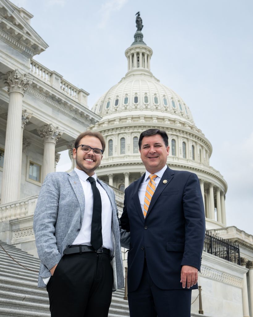 Two men in suits standing on Capitol Hill steps.