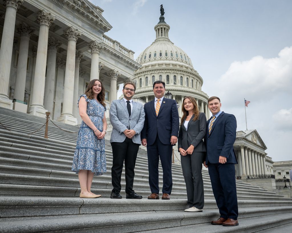 College students and man standing on concrete steps