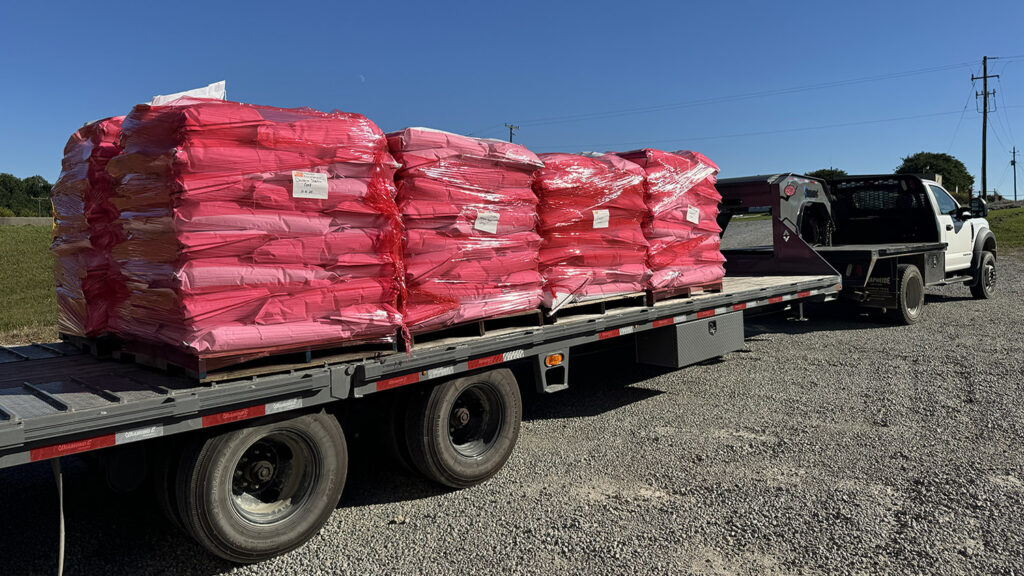 Feed is loaded on a tractor bed hauled by a truck