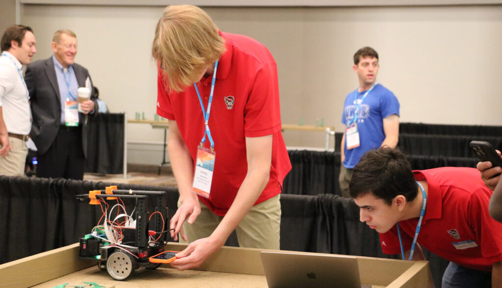 a person works on a small car-like robot