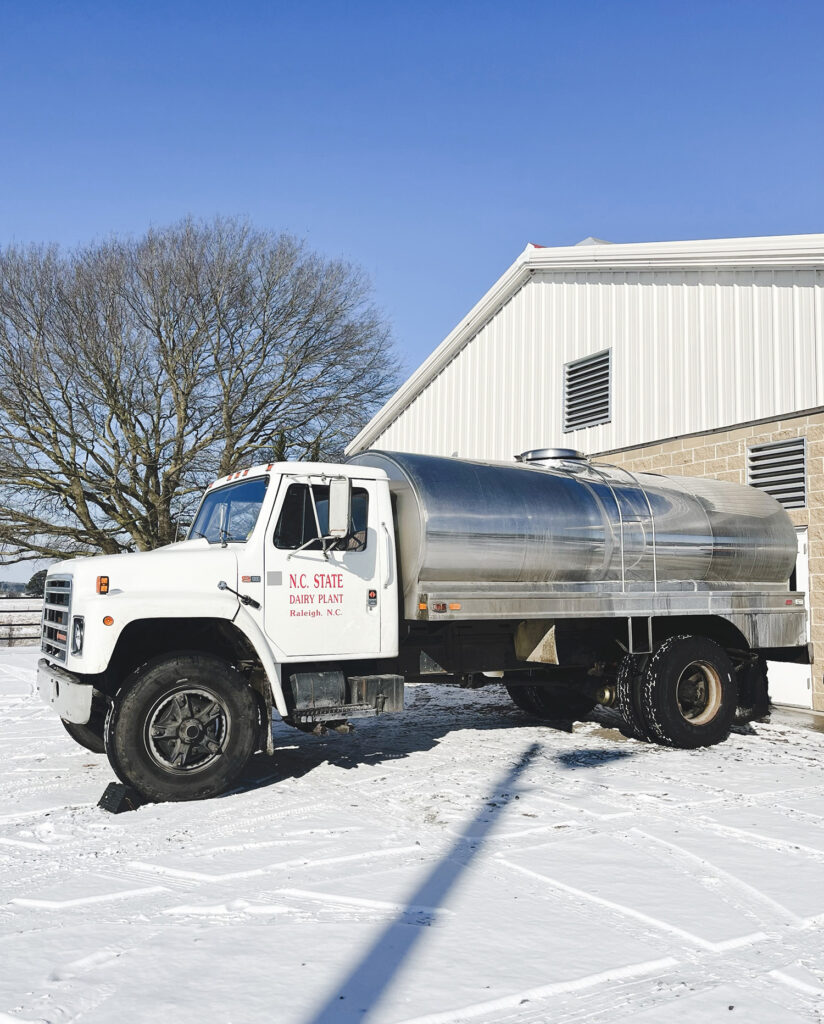 a dairy truck surrounded by snow