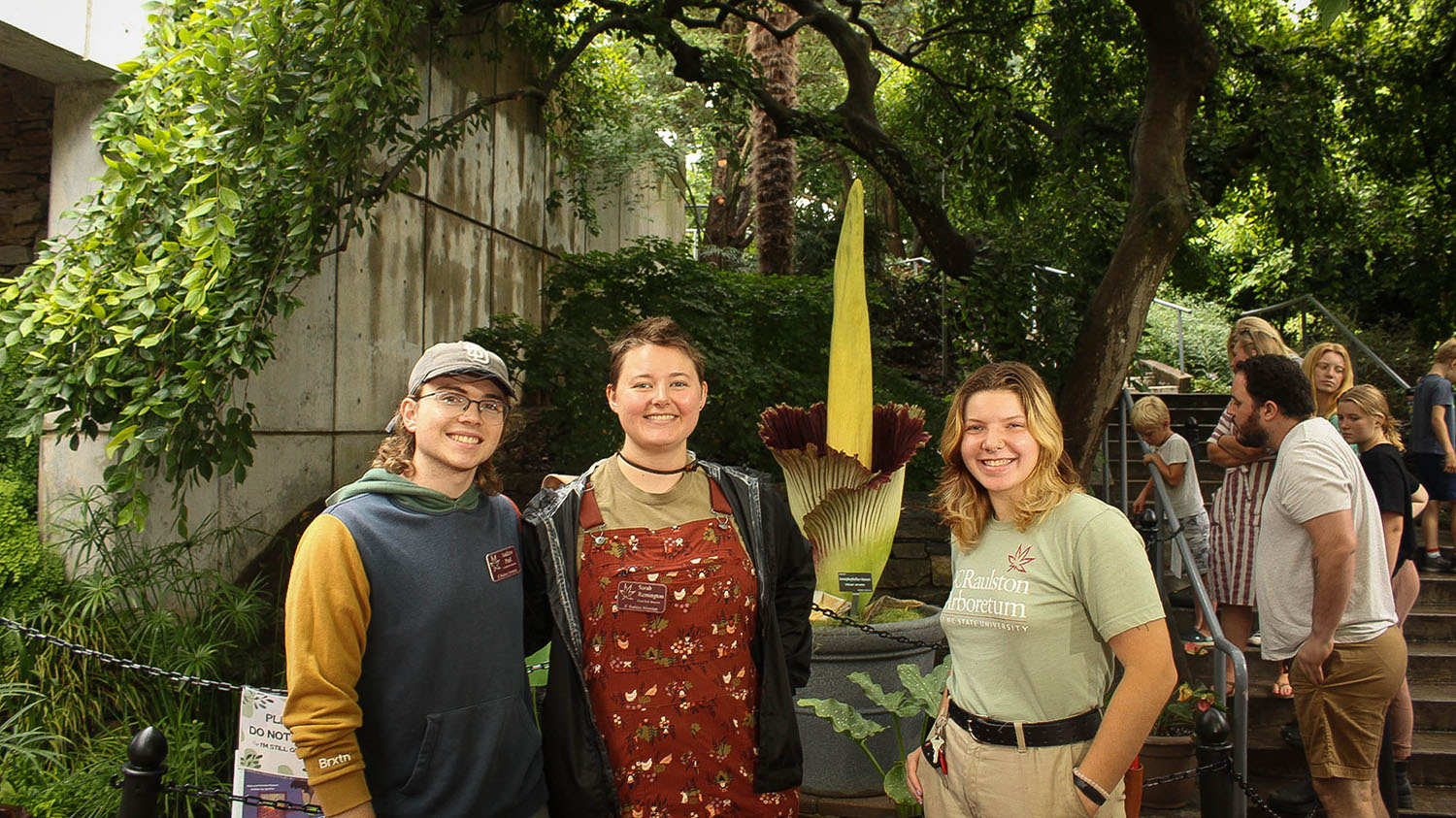 a group of people standing outside with a corpse flower