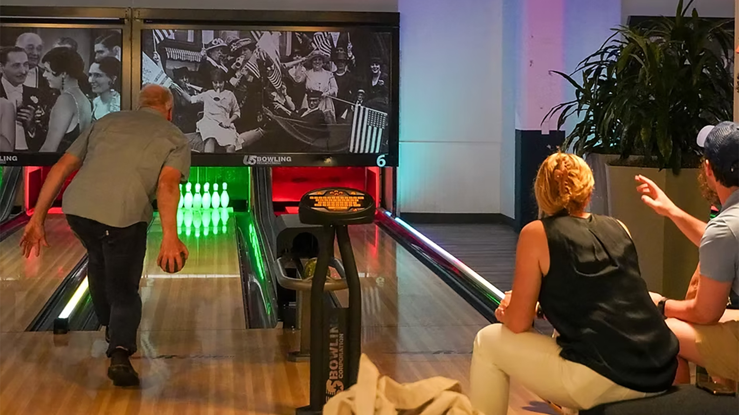 a man bowls at a bowling alley
