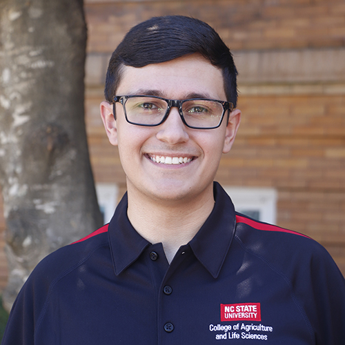 Young man in glasses in black shirt smiling