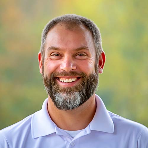 a man with a beard wearing a white polo shirt