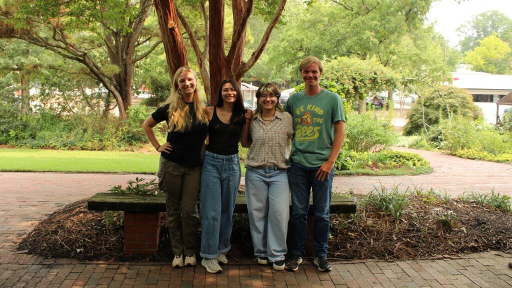 Lucas on far right poses for a group photo with three other students in a garden
