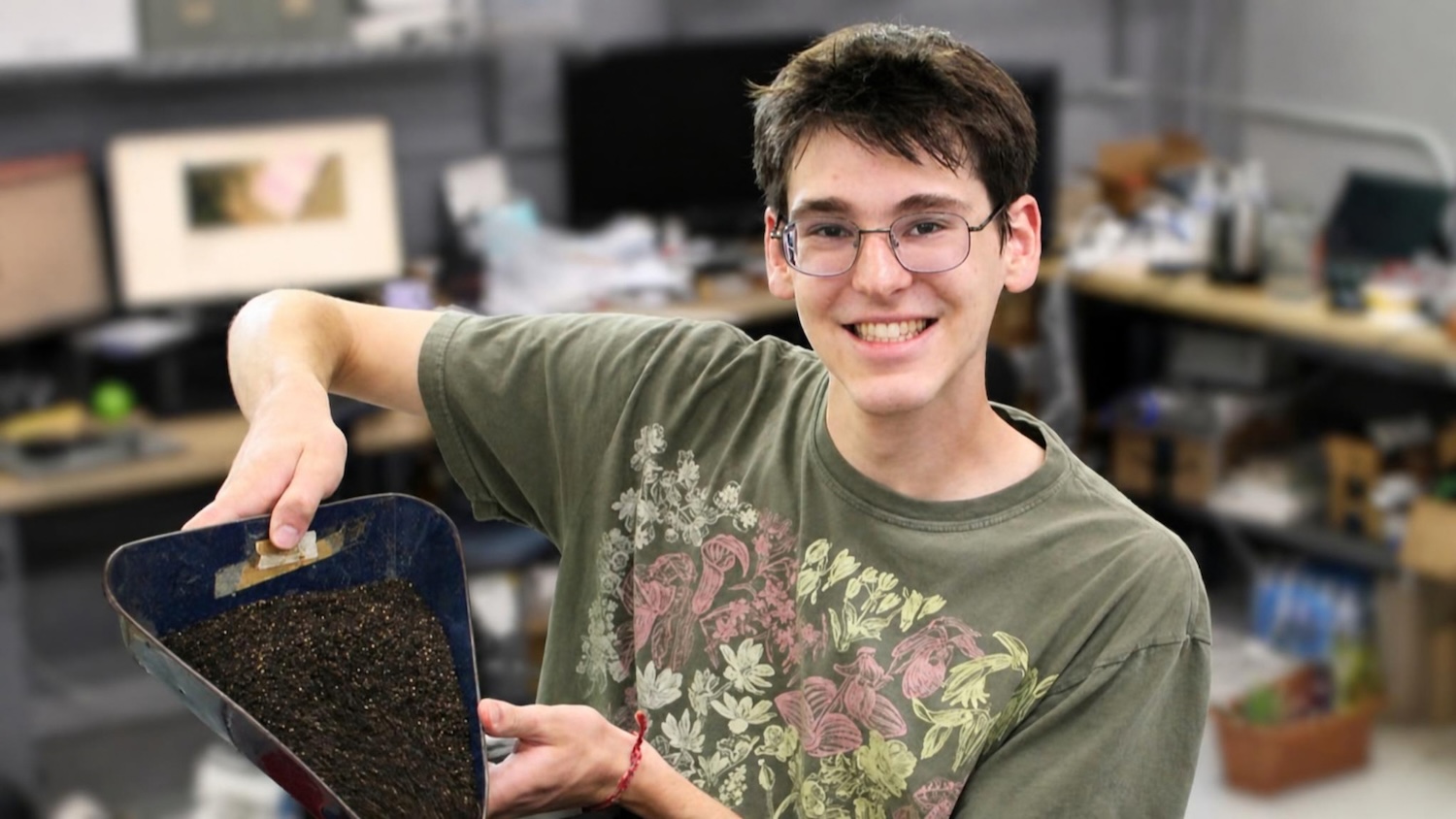 Student pours seeds into a mechanical device
