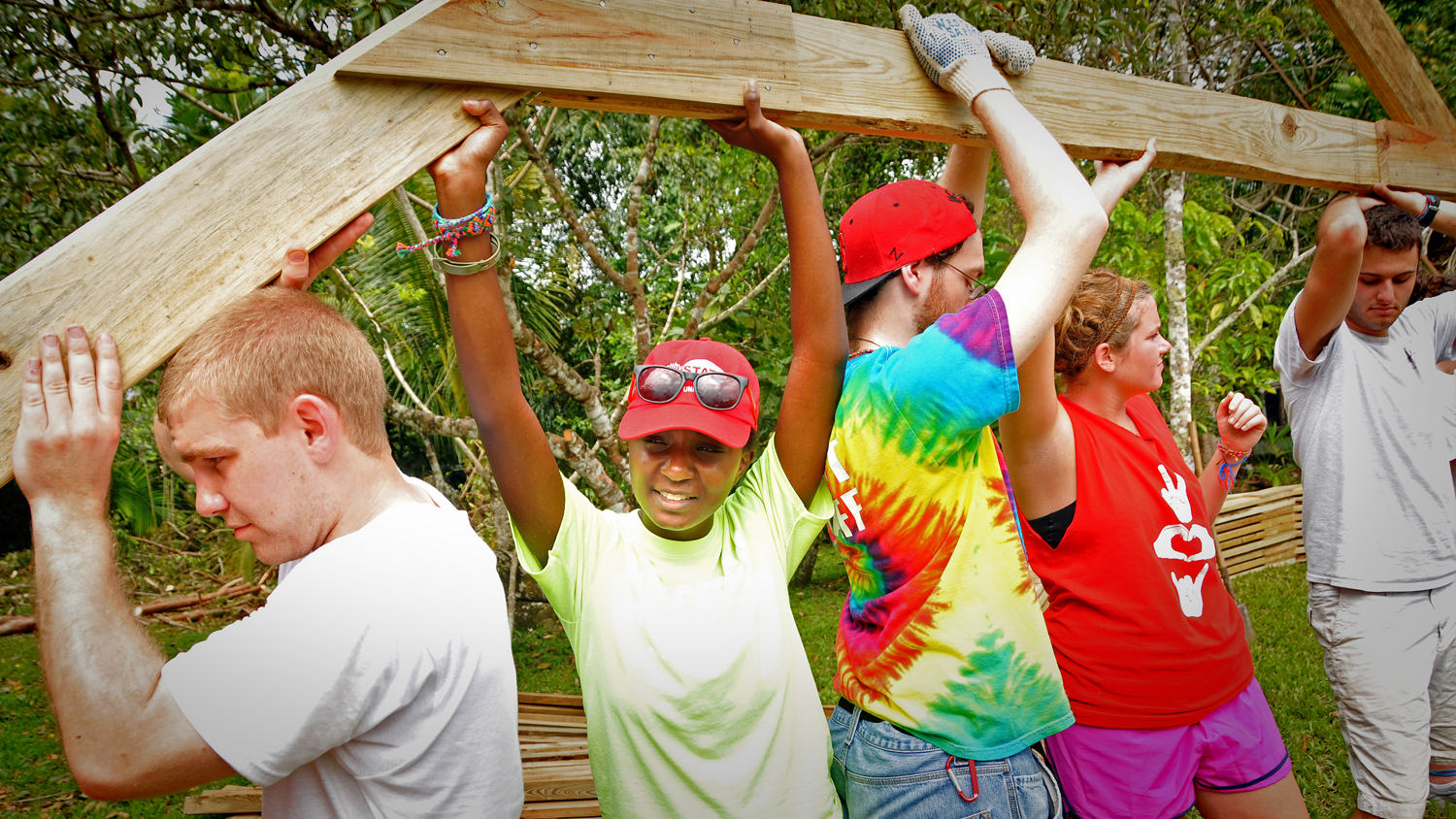 Diverse students building a house