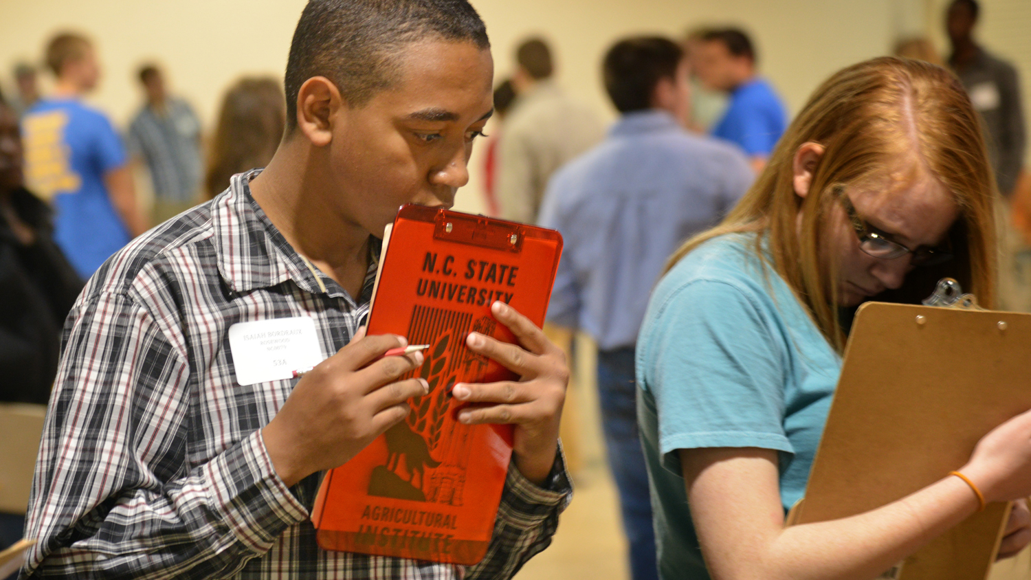 Students holding clipboards during an event.