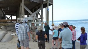 Standing next to a house that is about to fall into the sea, Vepraskas explains why coastal erosion occurs on the Outer Banks. Photo by Adam Howard.