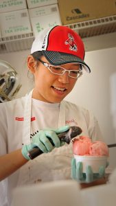 Student scoops strawberry Howling Cow ice cream at the NC State Fair.