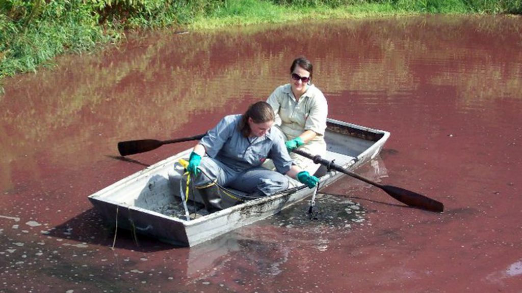 Eve Honeycutt canoes in sludge