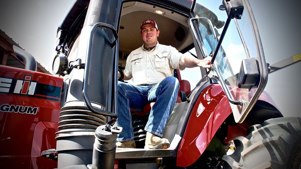 CALS grad Brandon Batten sitting on a tractor