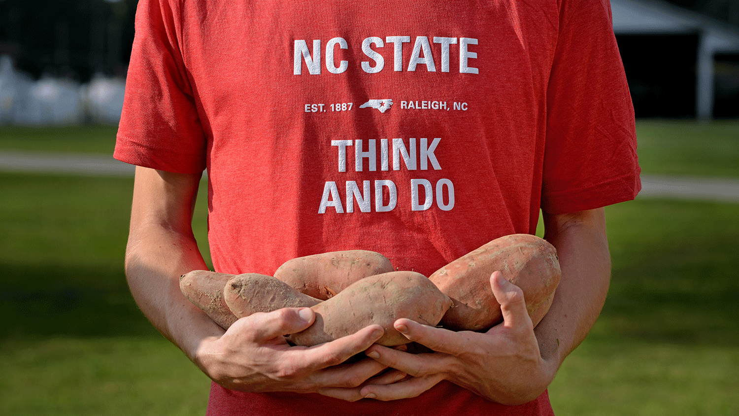 Student holding sweet potatoes.