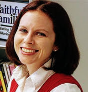 Head shot of a woman in front of books in bookshelves