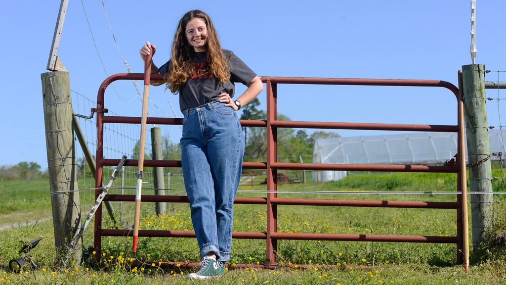 CALS Agroecology student Eliza Hardy stands by a fence