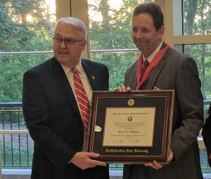 Two men holding a plaque.