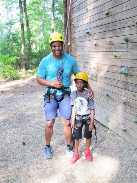 Photo of a man and a boy in rock-climbing gear