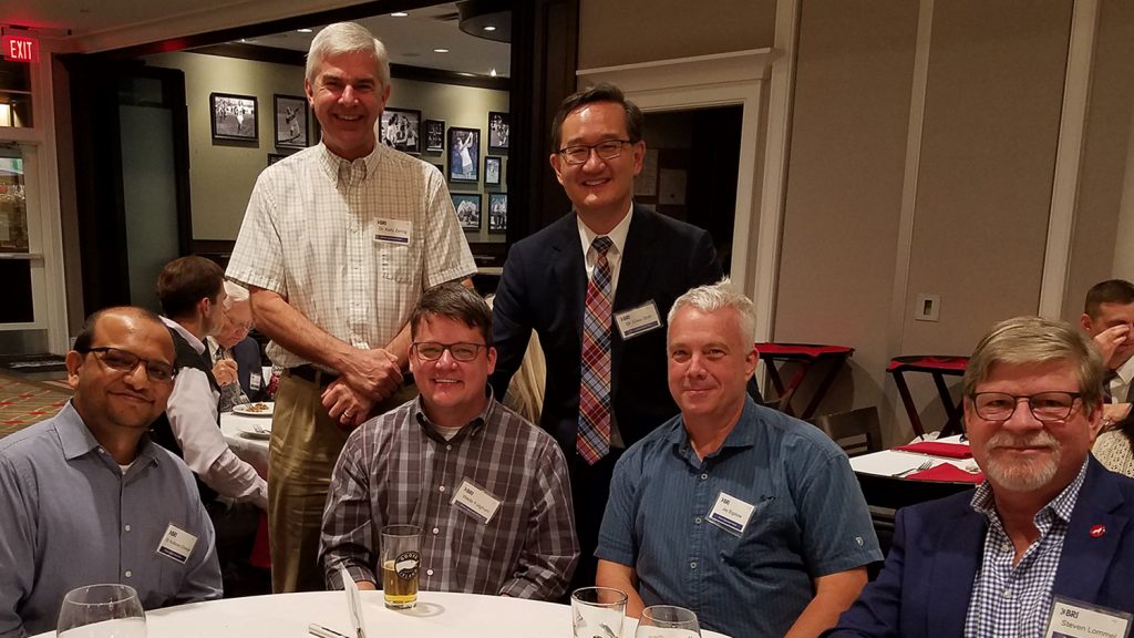 Six men at a white-tablecloth event.