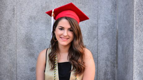 An NC State CALS student named Alex Burd sits in a graduation cap against a gray background.