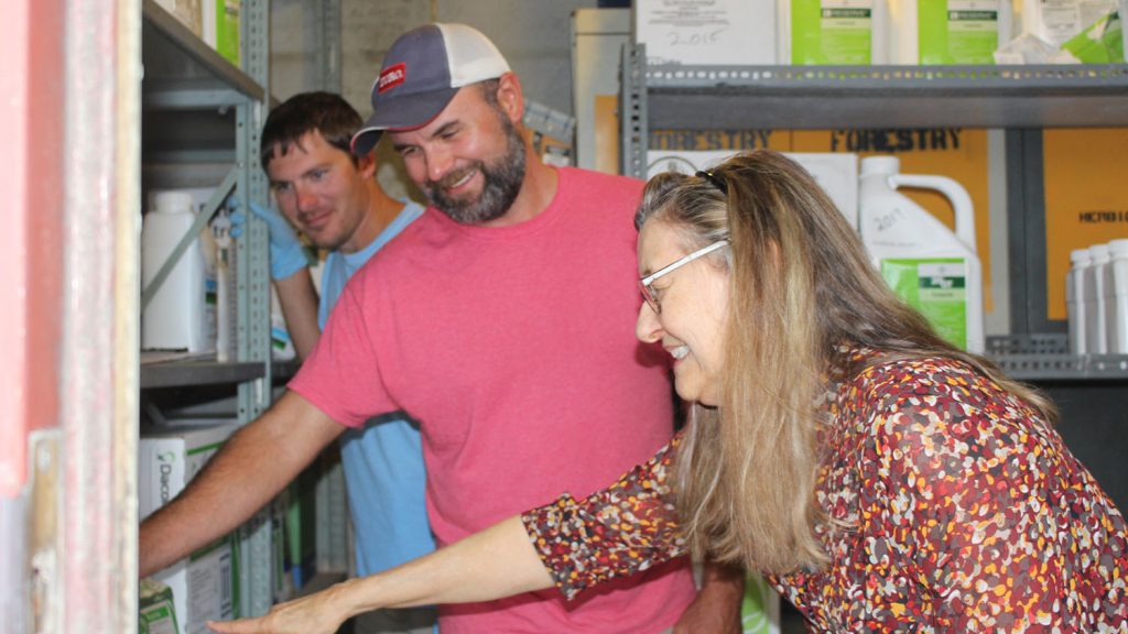 Candy Orr with Marty Parish and Dustin Corbett within a pesticide storage bunker.