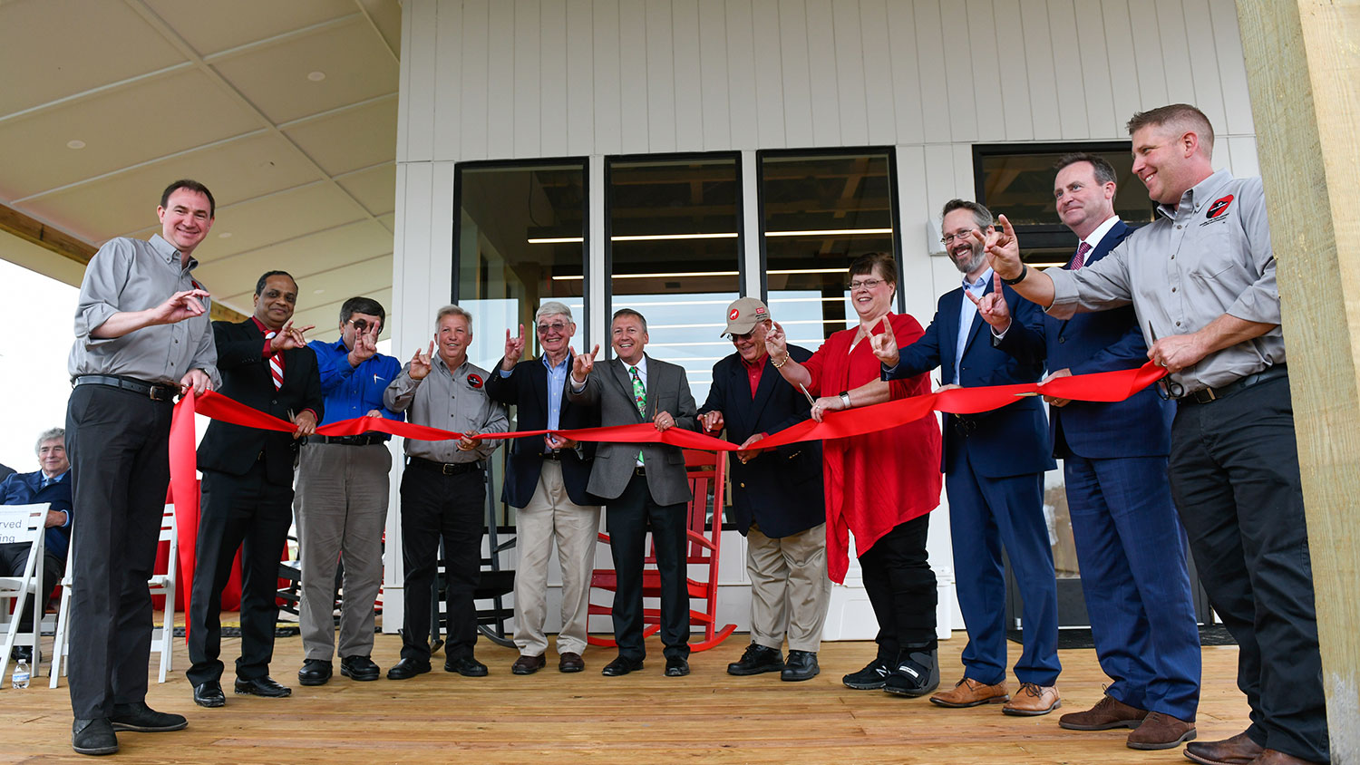 Dean Linton (center) and others holding a ribbon at the new Howling Cow Dairy Education Center and Creamery.