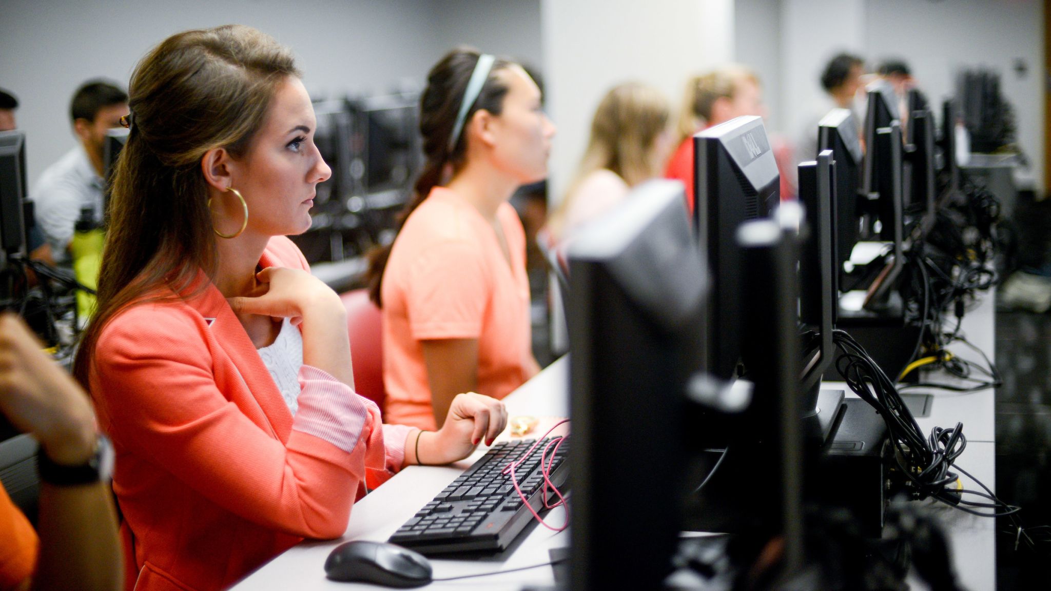 students sitting in front of computer monitors