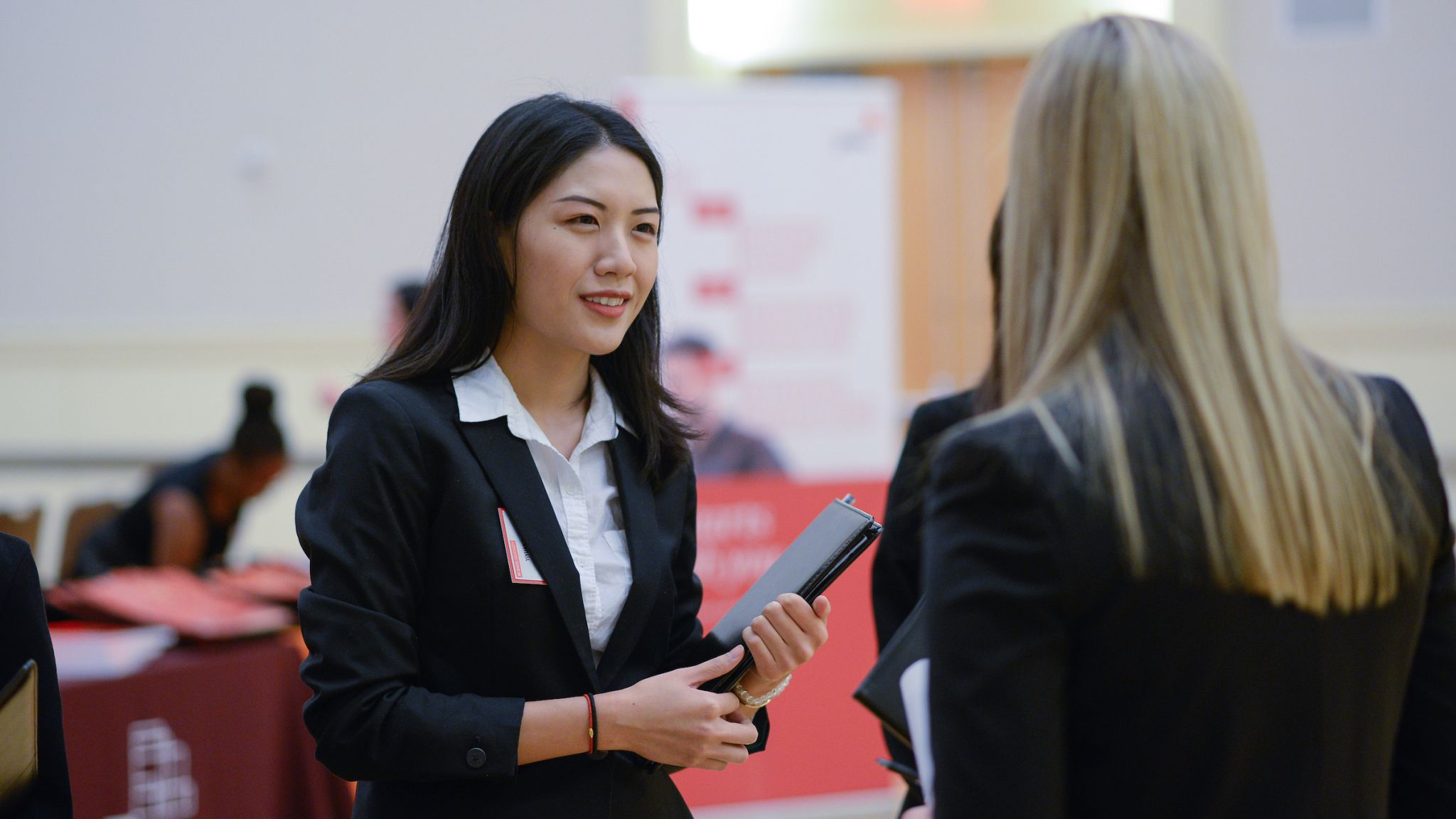 Student in a suit talking with another student.