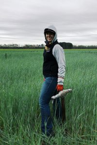 Young woman wearing a hood in an open field