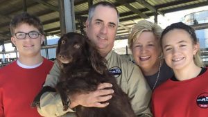 A family holding a dog 