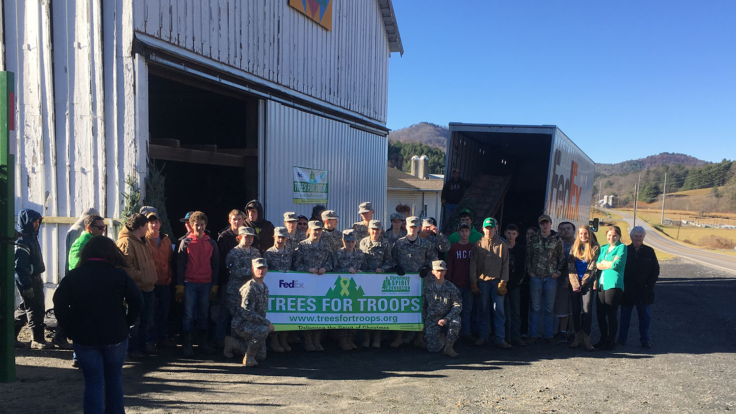 A group photo of ROTC cadets after loading a truck full of Christmas Trees for military bases across the country.